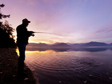 Man Catching A Fish At Sunset, Hood Canal, Washington State, USA