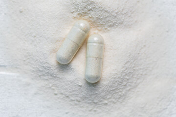 collagen in tablets and powder on wooden white background.