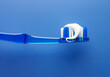 © SuperStock - Close up of toothbrush and toothpaste with blue background