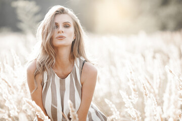 Beautiful blond woman closeup portrait outdoors. Smiling face. Lovely lady at summer background. Emotional female outdoors.