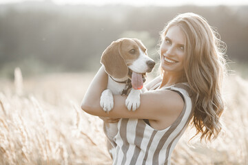 Wall Mural - Attractiive young woman outdoors with her pet. Owner and dog together. Friends forever. Lady and beagle