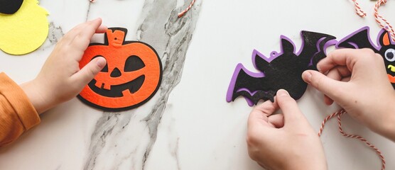 Children siblings sister and brother making decorations for Halloween party celebration. Do it yourself, diy, creativity, holiday concept. Banner.