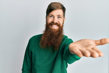 Poster - Redhead man with long beard wearing casual clothes smiling friendly offering handshake as greeting and welcoming. successful business.