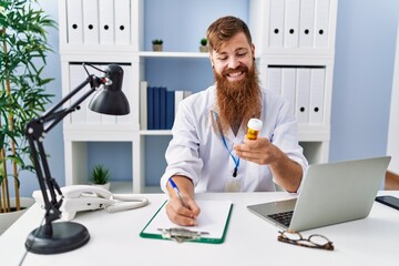 Poster - Young redhead man wearing doctor uniform prescribe pills at clinic