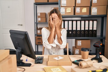 Canvas Print - Young blonde woman working at small business ecommerce with sad expression covering face with hands while crying. depression concept.