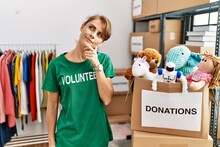 Beautiful Caucasian Woman Wearing Volunteer T Shirt At Donations Stand With Hand On Chin Thinking About Question, Pensive Expression. Smiling With Thoughtful Face. Doubt Concept.