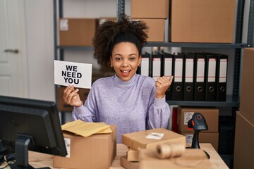 Poster - Young african american woman working at small business ecommerce holding banner screaming proud, celebrating victory and success very excited with raised arms