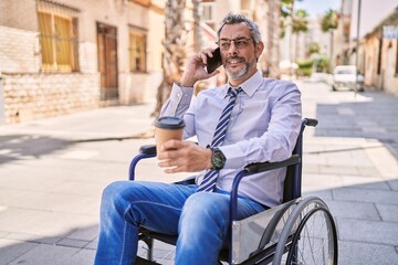 Sticker - Middle age hispanic man sitting on wheelchair talking on the smartphone at street