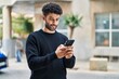 © Krakenimages.com - Young arab man smiling confident using smartphone at street