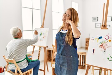 Sticker - Hispanic woman wearing apron at art studio smiling doing phone gesture with hand and fingers like talking on the telephone. communicating concepts.