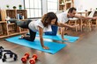 © Krakenimages.com - Middle age hispanic couple smiling happy stretching on the floor at home.