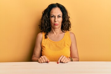 Poster - Beautiful middle age woman wearing casual clothes sitting on the table skeptic and nervous, frowning upset because of problem. negative person.