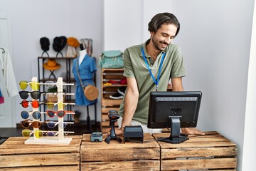 Wall Mural - Handsome hispanic man working as shop assistance at retail shop