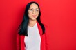 © Krakenimages.com - Beautiful hispanic woman with nose piercing wearing casual look and glasses smiling looking to the side and staring away thinking.