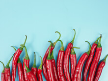 Chili Peppers Isolated On Blue Background. Red Hot Chili Peppers As An Ingredient Of Asian And Mexican Cuisine And Spices
