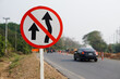 © Sanhanat - Traffic road sign with symbols of arrows to warn drivers do not overtake that can cause car accidents beside the rural road.