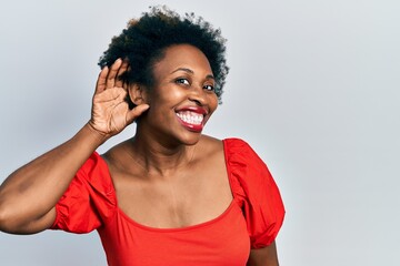 Poster - Young african american woman wearing casual clothes smiling with hand over ear listening an hearing to rumor or gossip. deafness concept.