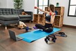 © Krakenimages.com - Young hispanic woman smiling confident having online traininig with dogs using dumbbells at home