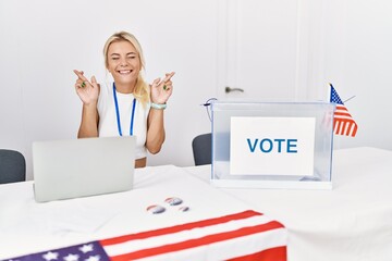 Sticker - Young caucasian woman at america political campaign election gesturing finger crossed smiling with hope and eyes closed. luck and superstitious concept.