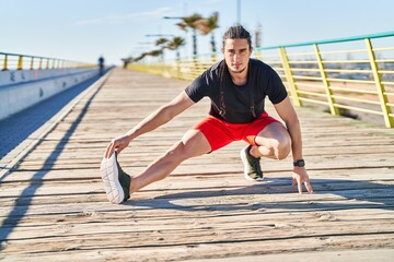 Young man stretching legs at street