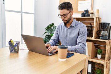 Wall Mural - Young arab man using laptop working at office