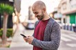 Young man smiling confident using smartphone at street