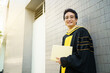 © DG PhotoStock - Happy Asian graduate student holding the diplomas on hand during the university graduation ceremony.
