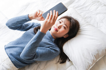 Young woman use the smartphone before going to sleep in bed