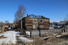 A Burnt-out Old Wooden House. An Abandoned And Dilapidated, Half-burnt Old Wooden House.