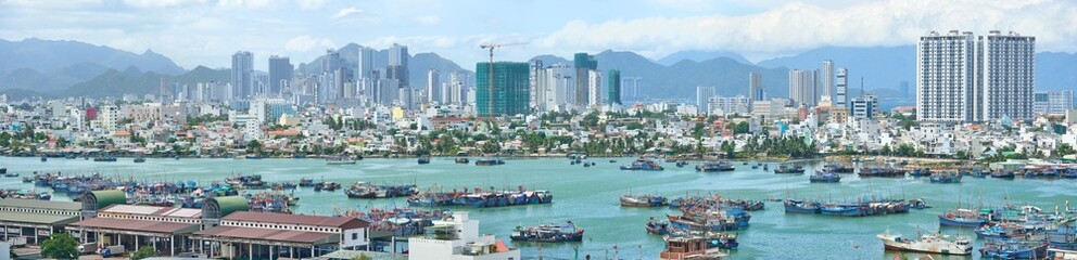 Wall Mural - Panoramic view of tourist city of Nha Trang off coastline with fishing boats. Khanh Hoa province, Viet Nam