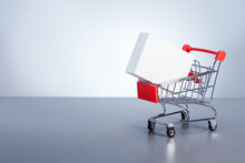  Shopping Cart With Boxes On Grey Background With Copy Space.  Sale, Discount, Shopping, Delivering Service Concept.