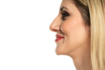 Wall Mural - Profile portrait of a young smiling woman with a humpbacked nose on a white background