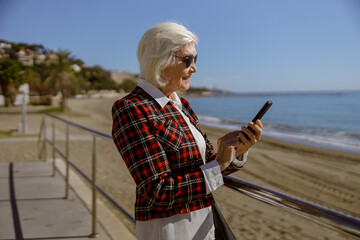 Wall Mural - Photo of charming woman using phone outdoors