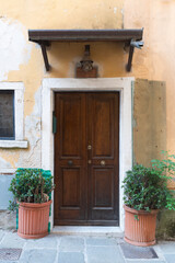  Ancient door of an Italian house with marble portal and canopy