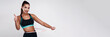 © khmelev - Billboard image. Strong slim attractive white fitness female in sport suit measuring waist and shows thumb up gesture on gray isolated background