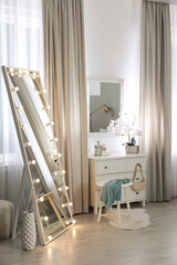 Wall Mural - Large mirror with light bulbs and chest of drawers in stylish room. Interior design