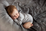 Fototapeta  - Mały chłopiec śpi na łóżku jak mały bobas