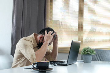 Sticker - Man working from home on her laptop looked worried, exhausted, and overwhelmed.