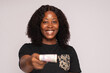 © Confidence - african lady stretches money forward towards viewer