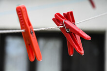 Plastic Clothespins On A Clothesline In Front Of House. Plastic Clothes Pegs On The Rope. Clothespin On Washing Line.