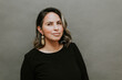 © cesar - Middle aged hispanic woman standing in front of gray background with inspiring look