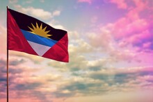 Fluttering Antigua And Barbuda Flag Mockup With The Space For Your Content On Colorful Cloudy Sky Background.