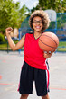 © JENOCHE - girl with afro hairstyle with a ball on a basketball court