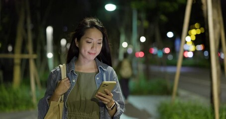 Wall Mural - Woman walk in the street and use of mobile phone at night