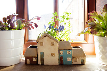 Ceramic pot for house plants in the shape of a house on the window