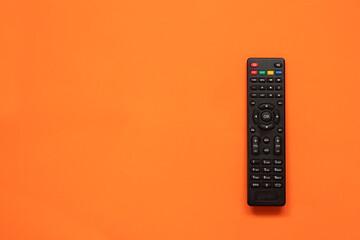 TV remote controller on orange background. Space for text. Top view