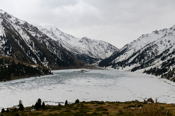 Wall Mural - Beautiful mountain lake with ice and snow. Big Almaty lake in winter time. Kazakhstan.