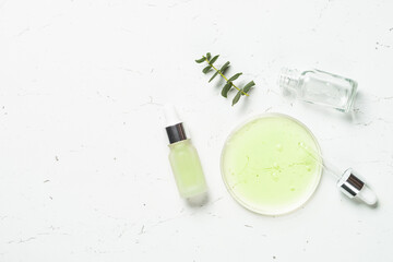 Poster - Essential oil, eucalyptus oil . Glass petri dish with essential oil at white background. Top view with copy space.