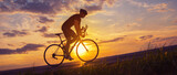 Young sports man cycling with bicycle on the road in summer