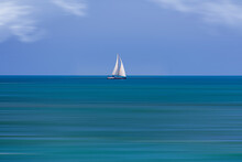  Calm Sea Landscape With White Sailboat Against Blue Sky And Long Water Time